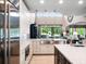 Bright, open kitchen with stainless appliances, undermount sink, and a breakfast bar overlooking the living area at 3664 Farm Bell Pl, Lake Mary, FL 32746