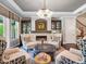 Charming living room with a stone fireplace, chandelier, and built-in cabinets for display at 3664 Farm Bell Pl, Lake Mary, FL 32746