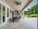 Outdoor kitchen featuring a grill, stainless steel range hood, dining table, with outdoor seating overlooking the lawn at 3664 Farm Bell Pl, Lake Mary, FL 32746