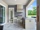 Outdoor kitchen featuring a built-in grill, sink, stainless steel cabinets, an island, and barstool seating at 3664 Farm Bell Pl, Lake Mary, FL 32746