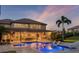 Stunning outdoor pool area with a slide, lounge chairs, and covered patio at twilight at 3664 Farm Bell Pl, Lake Mary, FL 32746