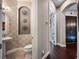 Elegant powder room featuring decorative wall accents, stylish pedestal sink, and neutral tile flooring at 3664 Farm Bell Pl, Lake Mary, FL 32746