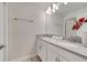 Bright bathroom featuring double vanity, stone countertops, modern lighting, and neutral accents at 368 Ocean Course Ave, Davenport, FL 33896