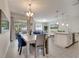 Open dining area with modern lighting, a wood table, and a view into the living room at 368 Ocean Course Ave, Davenport, FL 33896