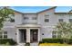 Charming townhome with modern facade, brick accents, a covered entry, and professionally landscaped front yard at 368 Ocean Course Ave, Davenport, FL 33896