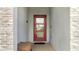 Close up of a red front door with glass and stone accent wall and a brown bench on the porch at 368 Ocean Course Ave, Davenport, FL 33896