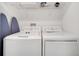 Well-equipped laundry room with modern washer and dryer units, as well as a shelf for storage at 368 Ocean Course Ave, Davenport, FL 33896