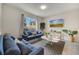 Cozy living room with comfortable blue sofas, natural light, and serene views of the outdoor living space at 368 Ocean Course Ave, Davenport, FL 33896