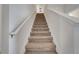 Carpeted staircase featuring white walls and natural light, creating an inviting transition between floors at 368 Ocean Course Ave, Davenport, FL 33896