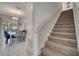 Carpeted staircase leading to the upper level, complemented by a dining area with ample natural light at 368 Ocean Course Ave, Davenport, FL 33896