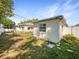 Backyard featuring a well-maintained lawn, a white fence, and exterior views of the home with windows at 370 E Waldo St, Groveland, FL 34736
