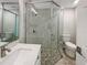 Modern bathroom featuring a glass-enclosed shower, marble vanity top, and updated fixtures at 370 E Waldo St, Groveland, FL 34736
