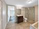 Bathroom featuring neutral paint colors, marble-look tile, glass enclosed shower and a separate tub at 370 E Waldo St, Groveland, FL 34736