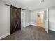Bedroom featuring a dark-stained, sliding barn door that adds a touch of rustic charm to the space at 370 E Waldo St, Groveland, FL 34736