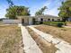 Extensive front yard view with a driveway leading to covered parking and lush landscaping with mature trees at 370 E Waldo St, Groveland, FL 34736
