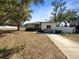 Charming single-story home showcasing mature trees, neutral paint, and a well-manicured front yard at 370 E Waldo St, Groveland, FL 34736
