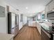 Modern kitchen with stainless steel appliances, white cabinets, and ample counter space overlooking the living room at 370 E Waldo St, Groveland, FL 34736