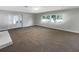 Spacious, well-lit living room with large windows, neutral carpet, and a decorative front door at 370 E Waldo St, Groveland, FL 34736