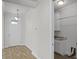 Hallway with tile flooring leading to a laundry room with granite countertops and white cabinets at 3723 Broadway St, Gotha, FL 34734