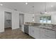 Well-lit kitchen featuring stainless steel appliances, white cabinets, granite countertops, and wood-look tile flooring at 3723 Broadway St, Gotha, FL 34734