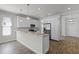 Bright kitchen with granite countertops, stainless steel appliances, white cabinets, and wood-look tile flooring at 3723 Broadway St, Gotha, FL 34734