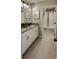 Bathroom with double sinks, gray countertops, white cabinets and tile flooring at 402 Cool Summer Ln, Davenport, FL 33837