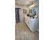 Bathroom with double sinks, quartz countertops, white cabinets, decorative mirror and tile flooring at 402 Cool Summer Ln, Davenport, FL 33837