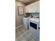 Well-lit laundry room with patterned tile flooring, overhead cabinets, and modern washer and dryer at 402 Cool Summer Ln, Davenport, FL 33837