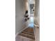 Carpeted staircase with a view of a brightly lit hallway and decorative wall art at 402 Cool Summer Ln, Davenport, FL 33837