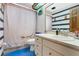 Cozy bathroom features a toilet, white and blue cabinets, a shower with a curtain and a mirror at 432 Taylorville St, Deltona, FL 32725