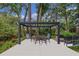 Back patio with pergola and outdoor dining table and seating provides a comfortable entertaining space at 450 Andrews Dr, Longwood, FL 32750