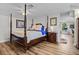 Spacious bedroom features wood floors and a four-poster bed with a nightstand and view into the kitchen at 450 Andrews Dr, Longwood, FL 32750