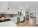 Modern kitchen boasts white cabinets, stainless steel appliances, and wood floors at 450 Andrews Dr, Longwood, FL 32750