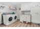 Functional laundry room equipped with modern washer and dryer, white cabinets, and shelving for efficient storage at 450 Andrews Dr, Longwood, FL 32750