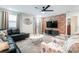 Cozy living room with a red brick accent wall, leather sectional, and stylish decor at 4501 Target Blvd, Kissimmee, FL 34746