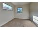 This bedroom features neutral carpeting, windows, and light gray walls at 4510 Ravinnia Dr, Orlando, FL 32809