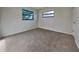 This bedroom features neutral carpeting, windows, and light gray walls at 4510 Ravinnia Dr, Orlando, FL 32809