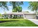 Single-story home with an attached garage and a well-maintained front lawn with garden at 456 Willowbrook Ln, Longwood, FL 32779