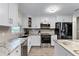 Modern white kitchen featuring stainless steel appliances, granite countertops, and ample storage at 456 Willowbrook Ln, Longwood, FL 32779