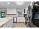 Well-lit kitchen featuring modern appliances, white cabinets, and a view of the backyard at 456 Willowbrook Ln, Longwood, FL 32779