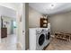Functional laundry room with modern washer and dryer, storage shelves, and neutral paint at 456 Willowbrook Ln, Longwood, FL 32779