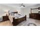 Well-lit main bedroom featuring a ceiling fan, neutral walls, and dark wood furnishings at 456 Willowbrook Ln, Longwood, FL 32779