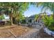 Spacious backyard featuring a well manicured lawn, mature landscaping, and a fire pit at 5547 Kingswood Dr, Orlando, FL 32810