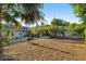 Backyard featuring a large fire pit, patio area, mature landscaping, and a shed at 5547 Kingswood Dr, Orlando, FL 32810