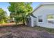 Backyard shed featuring double doors, a window, and surrounded by mature landscaping at 5547 Kingswood Dr, Orlando, FL 32810
