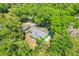 Aerial view of home with large yard surrounded by mature trees, a shed, and a detached garage at 728 E Clifford Ave, Eustis, FL 32726