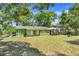 A green home features a spacious backyard with a patio under the canopy at 728 E Clifford Ave, Eustis, FL 32726
