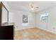 A simple bedroom with tile flooring, white walls, and natural light from two windows at 728 E Clifford Ave, Eustis, FL 32726