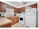 A functional kitchen featuring wooden cabinets, standard appliances, and laminate countertops at 728 E Clifford Ave, Eustis, FL 32726