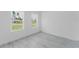 Bright bedroom featuring two windows and light gray flooring at 741 Marion Oaks Ln, Ocala, FL 34473